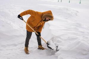 Man removing snow and ice from the sidewalk in front of house. Winter season photo
