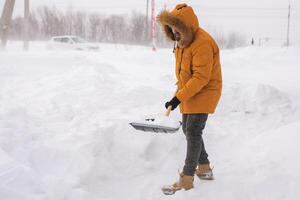 Man removing snow and ice from the sidewalk in front of house. Winter season photo