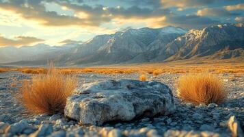 A rock in the middle of a desert with mountains in the background photo