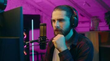 Contemplative Caucasian influencer gamer guy blogger man vlogger thinking game solution addict pensive streamer contemplate cyber sport at home blog presenter male smile idea brainstorm raising finger video