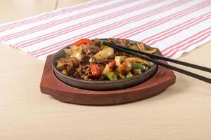 A bowl of food with chopsticks on a table photo