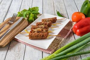 A plate with some meat skewers and vegetables photo