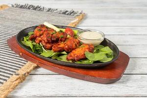A plate with chicken wings and salad on it photo