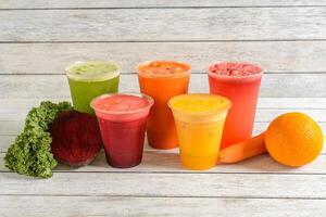 A group of different colored smoothies sitting on a table photo