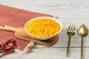Indian rice in a bowl with spoons and red chilli photo