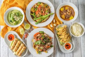 Various plates of food on a table with a bowl of soup photo