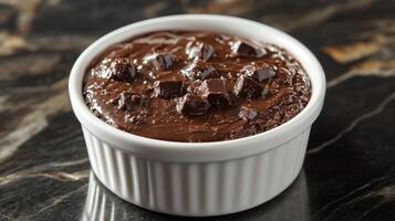 A small bowl of chocolate pudding on a marble counter photo