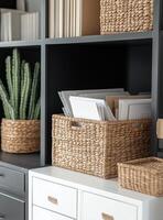 Organizing office supplies in a modern workspace with stylish baskets and greenery photo