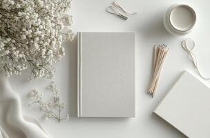 Minimalist workspace with a blank notebook and decorative flowers on a light background photo