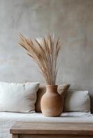 Rustic decor featuring dried pampas grass in a clay vase on a cozy neutral sofa photo