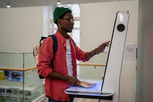 Progressive young man using self-service electronic terminal to pay in store without salesperson photo