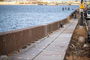 Embankment repair on Neva river strengthens and aligns granite slabs. Granite support on waterfront photo
