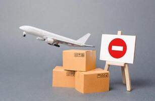 Cargo plane with boxes and an easel with a restriction sign. Restrictions on export of scarce and medical goods for the period of border closure quarantine and pandemic. Obstacle to globalization photo