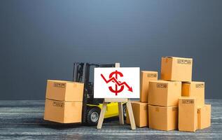 Forklift near boxes and easel with red dollar arrow down. Decline trade and production rates, decreased sales. Bad marketing, price reduction. Low import export. Economic reduced, industry degradation photo