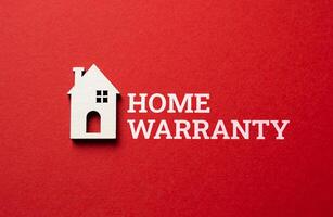 Home warranty and house figurine on red background. Cover unexpected repair costs and secure your investment. Modern solutions for homeownership peace of mind. photo