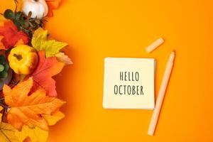 Notes with words Hello october and fall leaves. Concept of beginning of autumn and new season photo