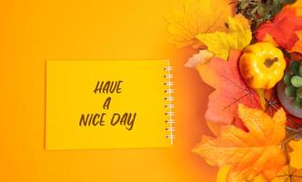 Notes with message Have a nice day and autumn leaves. Concept of good start to day. Top view, flat lay photo