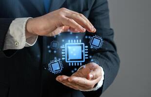 Businessman holding holograms of microchips and semiconductor components. Processors and microchips. Artificial intelligence and demand for computing power. photo