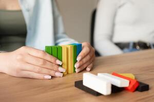 Hands align colorful blocks to form a vibrant pattern photo
