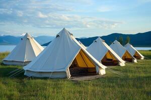 Glamping tents standing in a row near the lake and mountains photo