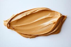 Creamy peanut butter spread on white background forming an oval shape photo