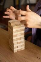 Building Team Skills Wooden block tower with hands in action symbolizes teamwork photo