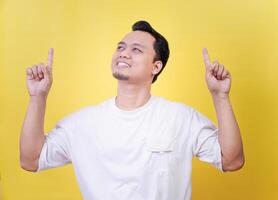 a man is pointing up with both hands on a yellow background photo