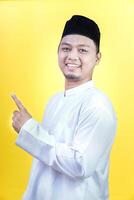 an Asian muslim man smiling and pointing upward photo