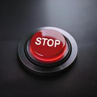 Round glowing red button with word STOP. Element of control panel. Modern equipment photo