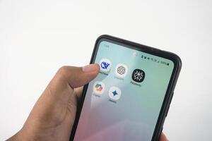 Hand Navigating Smartphone Apps Featuring AI Themed Icons. Such as Deepseek, ChatGPT, Copilot, Gemini, and Perplexity photo