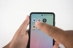 Hand Navigating Smartphone Apps Featuring AI-Themed Icons. Such as Deepseek, ChatGPT, Copilot, Gemini, and Perplexity photo
