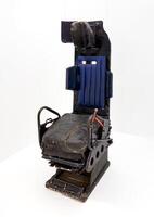 A detailed view of a Soviet-era fighter aircraft ejection seat, showcasing its rugged design, worn leather, and functional components. A remarkable relic of aviation history photo