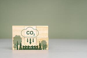 Wooden cubes with CO2 and green tree icons with the world map. Net-Zero Carbon Emissions by 2050 photo