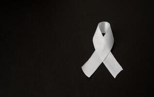 Top view of a white ribbon on a black background. Space for text photo
