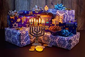 Jewish holiday Hanukkah Beautiful Chanukah decorations in blue and silver with gifts and dreidels and a Chanukiah with nine Chanukah candles for the photo