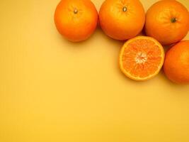 Top view of fresh oranges over a yellow background, in the studio photo