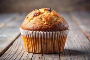 a muffin is sitting on top of a wooden table photo