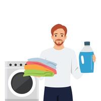 Man holds a bottle of detergent and a stack of folded laundry in front of washing machine. vector