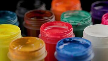 loopable rotating closeup background of opened small gouache paint jars video