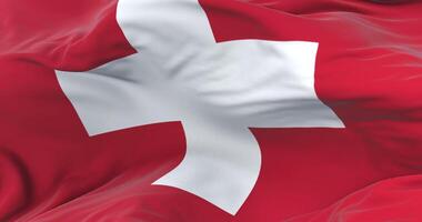 Switzerland flag waving at wind in slow in blue sky, loop video