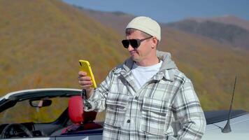 adult man using smartphone in mountain, connecting to mobile net during travelling across country video