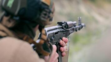 military shoots with a machine gun close up. A fighter of the American troops carefully aims at the enemy and pulls the trigger of the machine gun. Shot from a machine gun. video