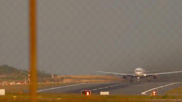 Commercial Airplane with an unrecognizable livery accelerating for takeoff, view through the airport fence. Flight departure. Plane on the runway video