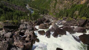 Aerial view of the cascading Uchar waterfall, flowing over rocks and forests video