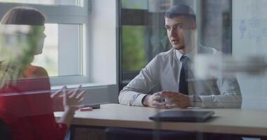 A director finalizes a contract with a client, sealing the deal with a firm handshake, exemplifying professionalism and successful client relations in a modern office setting. video
