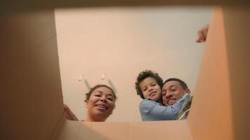POV point of view open cardboard box looking inside African American happy family joyful parents son kid little boy child unpacking parcel delivery online shop receive package unboxing moving day home video