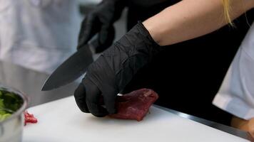 consistency of soft raw meat a piece of beef man cook cuts a fresh red raw fillet in a butcher's shop with a kitchen knife. Slices Premium ribeye meat or marbled beef. Steak production video