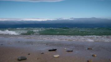 the shore of Lake Baikal with a sandy shore and small waves video