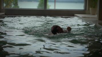 A Man Swimming Gracefully in Indoor Pool with a Serene and Peaceful View Around Him video