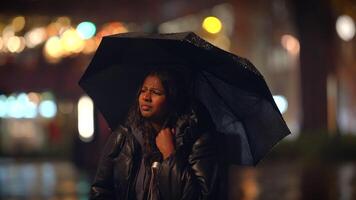 A solitary person with an umbrella walks in a rainy urban setting, in a chilly atmosphere video